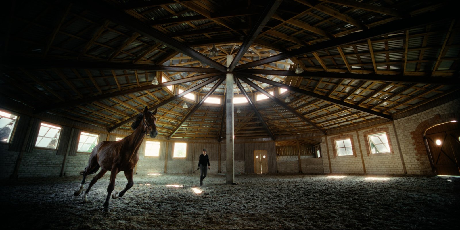 Horse and rider training in the indoor arena at Gintarinė Pasaga